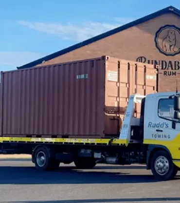 Towing truck transporting a shipping container.